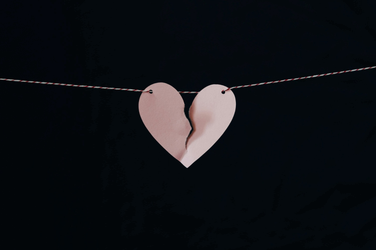 A broken paper heart dangling on a string