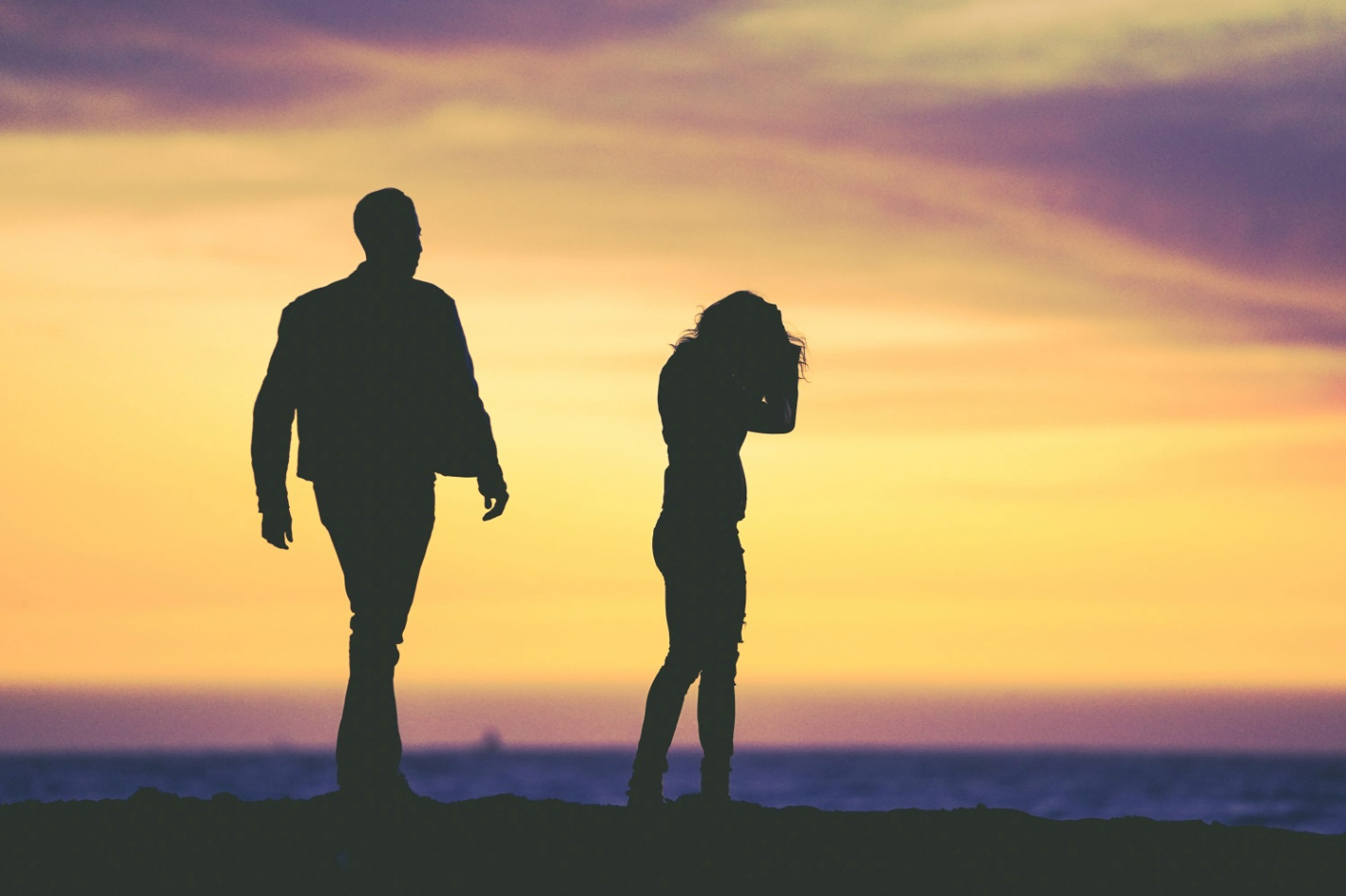Silhouettes of a man and woman arguing