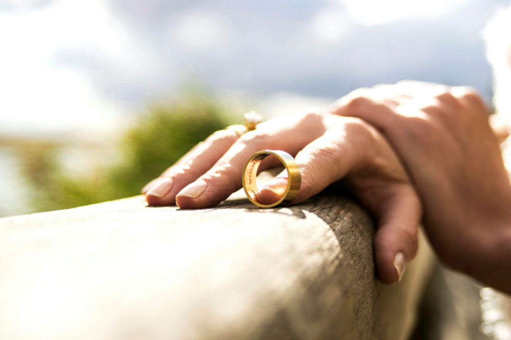 A person holding a gold wedding band